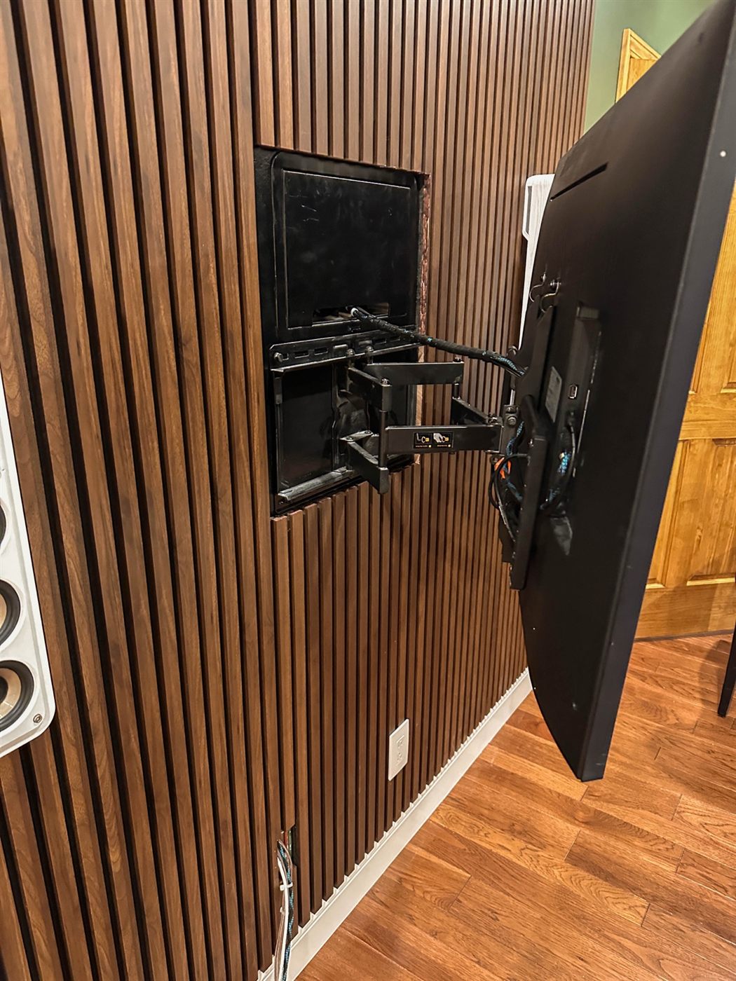 Articulating mount swung away from the wall to reveal the recessed box and the cable path running behind the TV