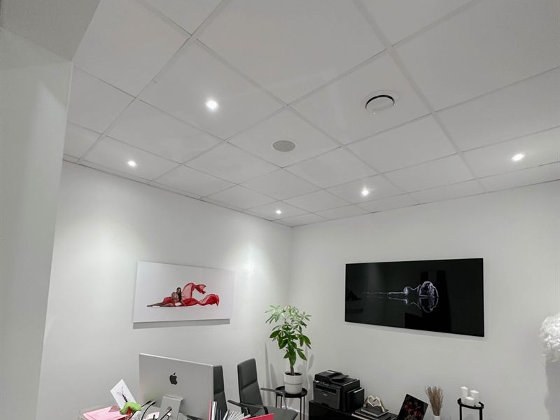 Private office with a wall-mounted display on an articulating mount above the desk